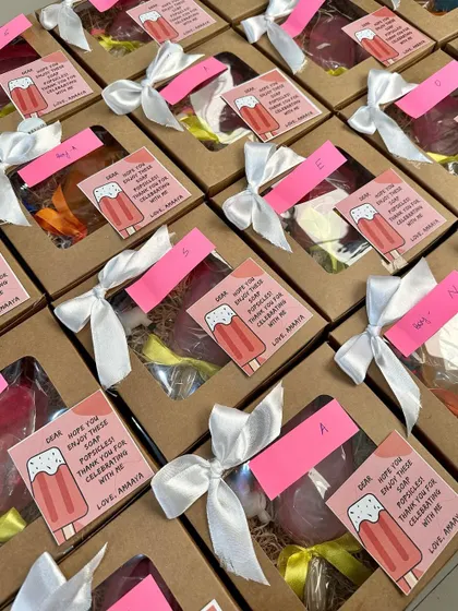 Rows of popsicle-themed gift boxes, all personalized with custom cards and ready for a party.