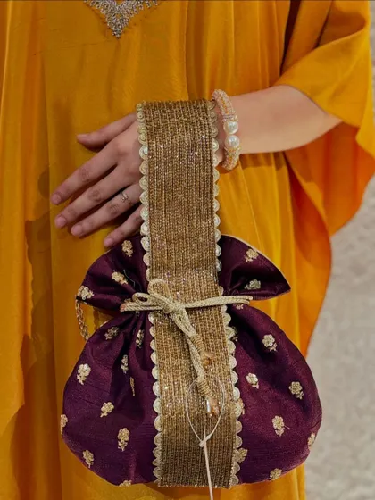 A full view of the majestic purple potli with its unique, wide handle, a true statement piece.