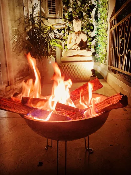 For those chilly winter evenings, I can set up a safe and stylish bonfire. This portable fire pit brings warmth and a mesmerizing glow to the balcony, creating a perfect gathering spot.