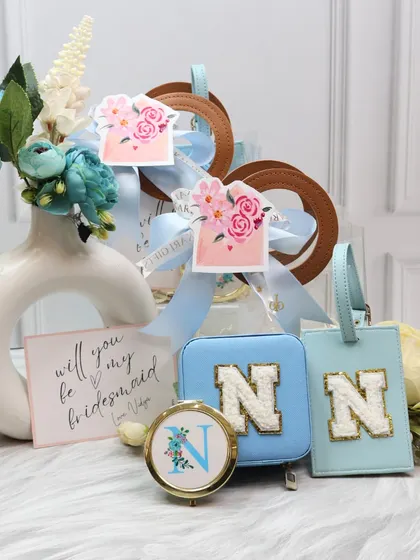 This bridesmaid hamper in a cool blue pastel shade offers a refreshing take on bridal party gifts. It includes a personalized jewelry case, luggage tag, and pocket mirror, making it a thoughtful and stylish proposal box.