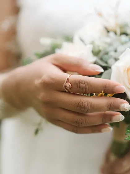 A close-up of the bride's hands, showcasing her beautiful ring and manicure as she holds her bouquet. It’s a simple, elegant shot that highlights a key wedding detail.