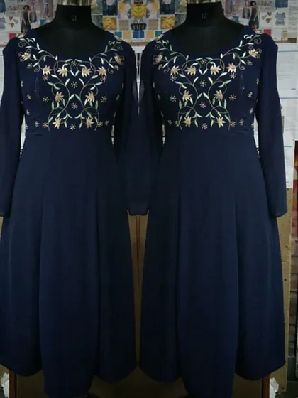 A full-length view of a navy blue Anarkali-style dress on a mannequin. The intricate gold embroidery on the yoke provides a beautiful contrast, making it an elegant option for evening festivities.