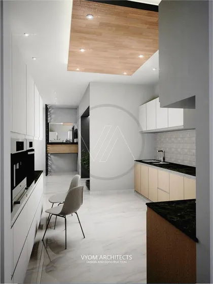 A minimalist parallel kitchen design with handleless cabinets and a wooden ceiling feature. The layout is clean and efficient, with a small seating area at the end for a quick breakfast.