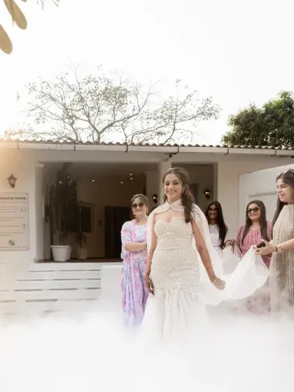 The bride makes her entrance, surrounded by mist and her loved ones. The soft light and dreamy atmosphere create a truly magical and ethereal moment.