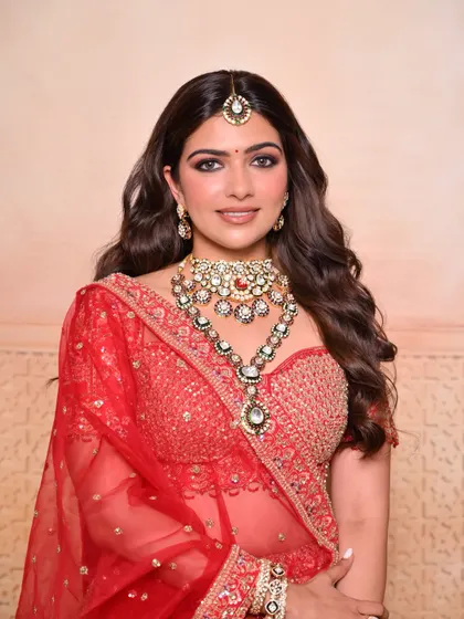 A front-facing portrait of the same traditional bridal look, highlighting the beautiful jewelry and the radiant makeup.