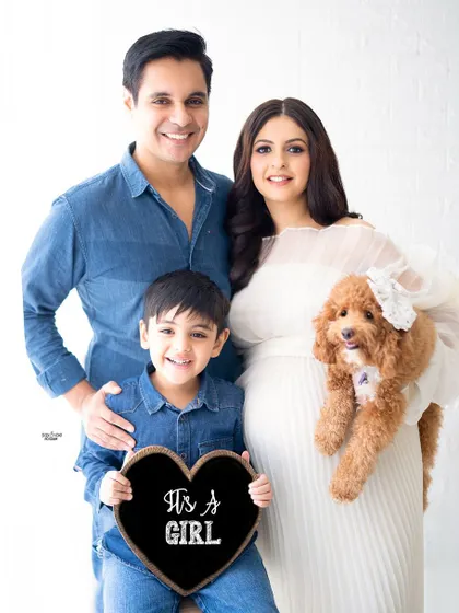The whole family is here, including the fur baby. This is such a happy and complete family portrait, announcing they're expecting a girl.