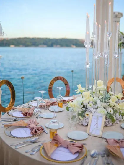 Another view of the seaside dining setup, showing the elegant place settings and the breathtaking view that guests can enjoy.