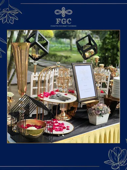 A creative and modern decor setup for a food station. It features geometric wireframe cubes, birdcage-style decorations, and scattered rose petals, showing our flair for contemporary event design.