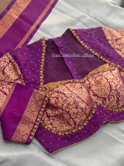 A purple blouse with gold brocade sleeves and a bustier-style front.