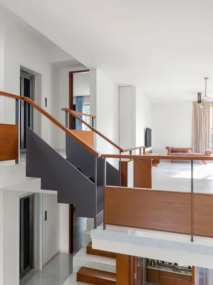 A view across the double-height void in the Copper House, showing the interplay of different levels. The staircase and bridge use a combination of steel and wood, creating a light yet strong connection between the private sections of the home.