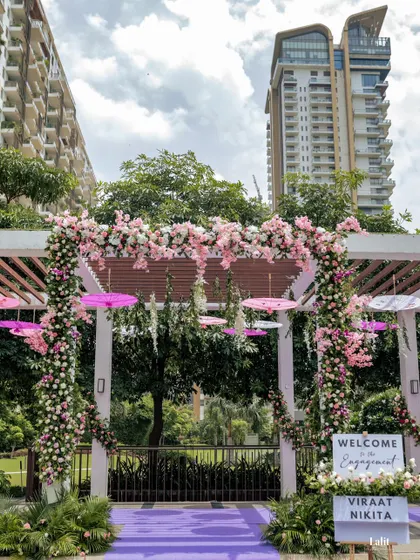 Another view of the floral-adorned pergola entrance, set against the modern architecture of the venue, showing the blend of nature and design.