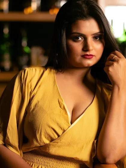 A close-up portrait in a lovely yellow dress. The warm lighting and the subject's direct gaze create a captivating and intimate mood.