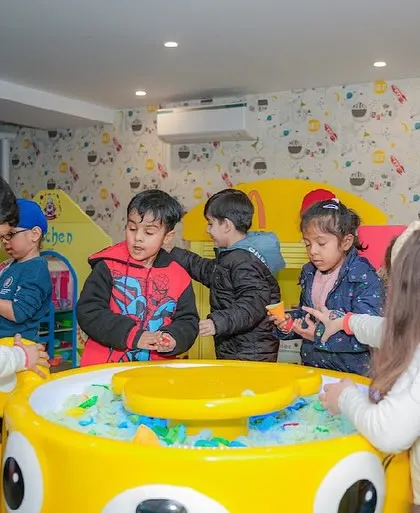 A group of children enjoying the sand table together.