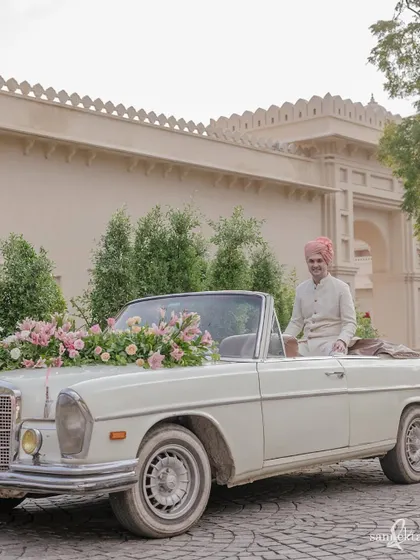 The groom, James, awaits the start of his baraat in a vintage Mercedes in Udaipur. It’s a classic, stylish shot that sets the tone for an elegant destination wedding.