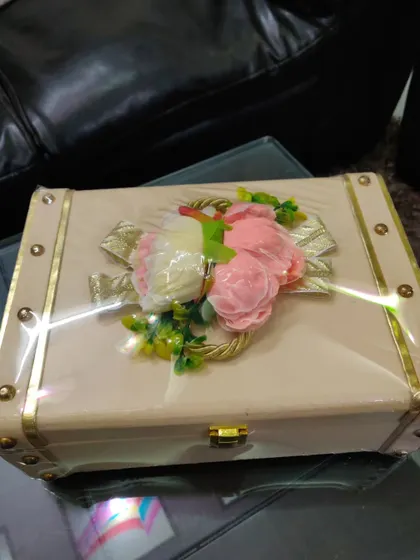 A fully packed and sealed luxury trunk box, adorned with a beautiful floral arrangement on top. This is how I ensure the gift looks stunning upon arrival.
