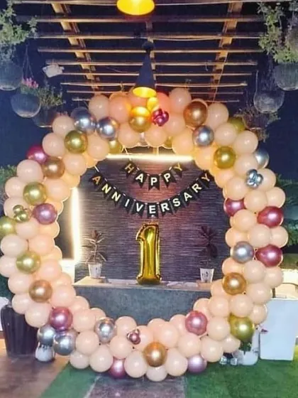 A first anniversary celebration on a beautiful terrace. I used a ring of peach, gold, and silver balloons to frame the "Happy Anniversary" banner and a large foil '1' balloon, making the most of the lovely outdoor space.