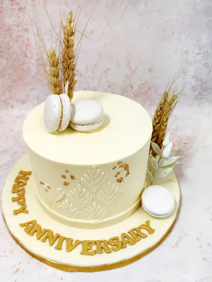 We embrace rustic charm with this elegant anniversary cake. A simple white cake is decorated with an embossed leaf pattern, gold leaf, and sprigs of wheat, creating a minimalist and natural design that is both modern and timeless.