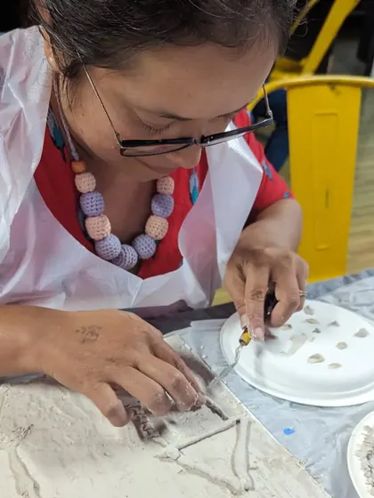 An artist deeply focused on her texture art piece. Our workshops provide a calm and inspiring environment to get lost in your creativity.