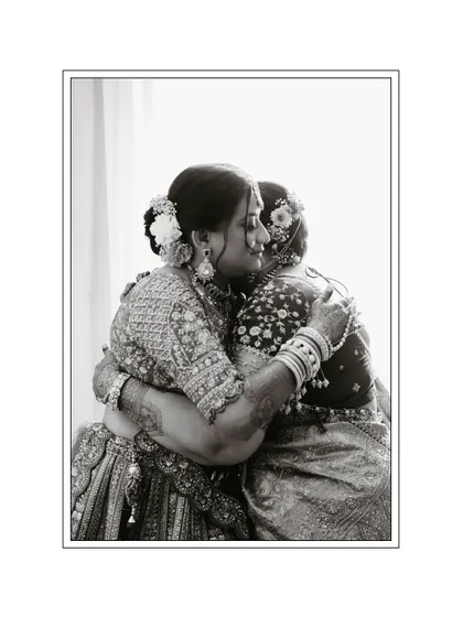 A touching black and white photo of the bride sharing a warm hug with her mother, capturing a moment of deep emotion.