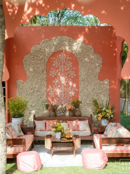 A beautiful seating nook at the 'Kesar Sehar' Haldi, featuring a textured archway and a hand-painted tree of life motif. The design celebrated Indian craftsmanship.