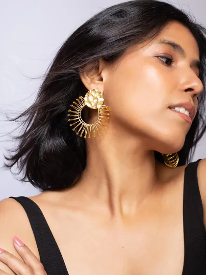 A close-up profile shot to showcase these intricate, sun-inspired statement earrings, ensuring the design details are clearly visible.