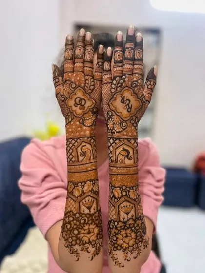 I can incorporate initials and symbols into your bridal mehandi. This design features the couple's initials inside decorative frames, along with traditional wedding motifs.