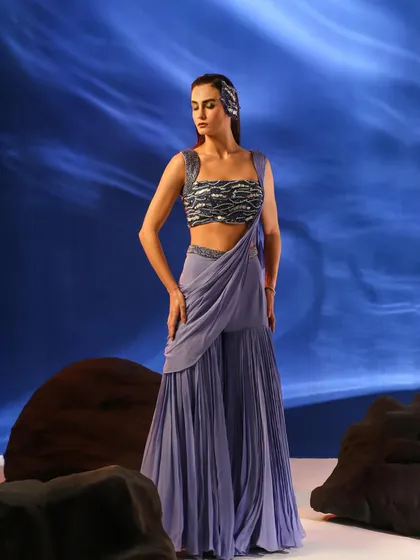 A full-length view of a lavender sharara set with a pre-draped dupatta. The styling is modern and fresh, perfect for a contemporary ethnic wear brand.