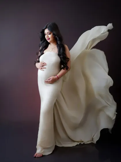 A graceful and elegant portrait. The flowing fabric of the off-white gown adds a beautiful sense of movement and drama to the shot.