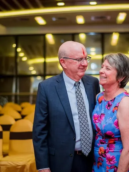 A sweet, candid portrait of an older couple, guests at the wedding, sharing a loving glance.