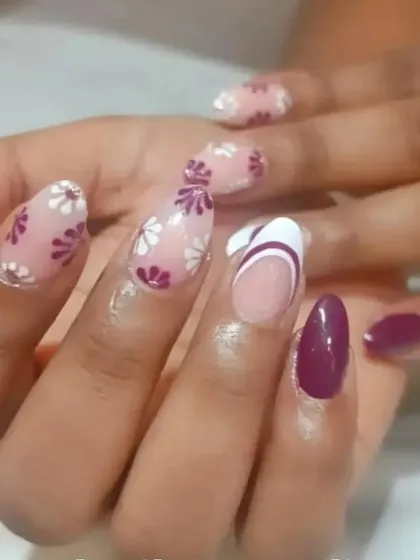 A creative set combining floral patterns, a solid color, and a modern French tip for a truly unique manicure.
