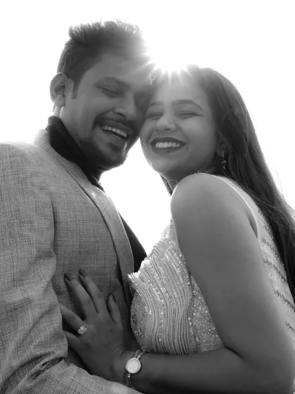 A joyful black and white portrait, with the sun flaring behind the couple, creating a bright and happy atmosphere.