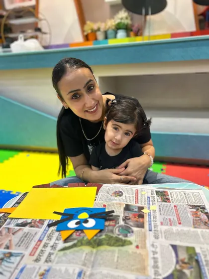 A mother and daughter smile for the camera with their finished craft, capturing a happy memory from our class.