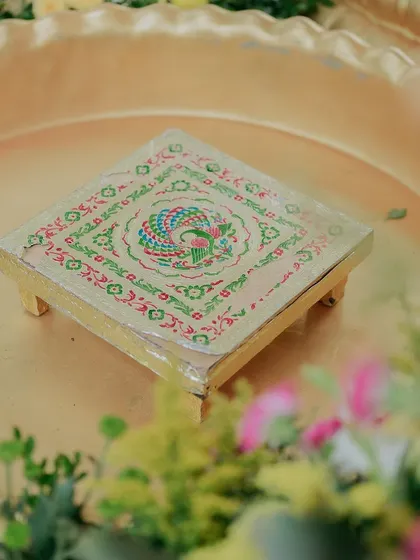 A small, hand-painted decorative stool used in the ceremony.