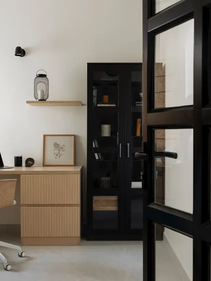 A view into the home office through the black-framed glass door, creating a sense of separation while still feeling connected to the rest of the home.