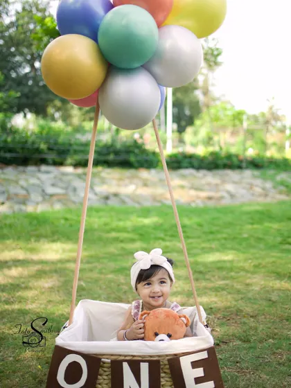 Cuddling a teddy bear during her first birthday adventure. Including a favorite toy can make the session even more personal and comforting for the child.
