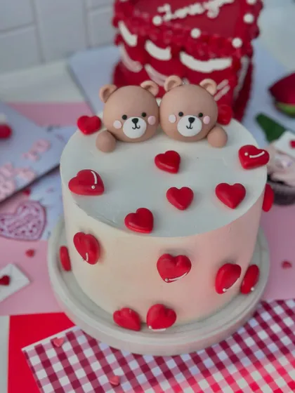 An adorable Valentine's cake featuring two cute teddy bears surrounded by little red hearts.