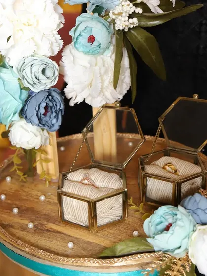 A closer view of the engagement ring platter, focusing on the delicate floral hoop and the elegant ring boxes.