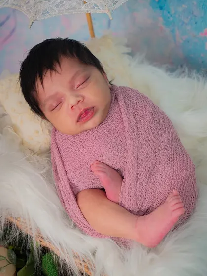 A close-up of the baby's sweet, sleepy face. The curled-up pose in the wrap mimics how they were in the womb, which is why it's so natural for them.