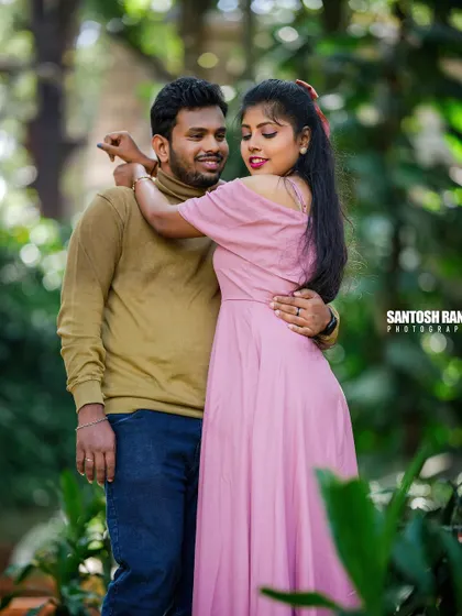 A tender embrace between a couple, surrounded by the vibrant green of a garden.