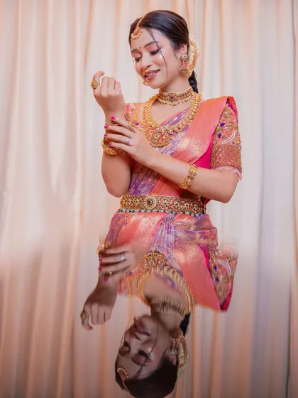 A creative shot reflecting her happiness and glow. The makeup is natural and subtle, designed to enhance her features and create a timeless South Indian bridal look.