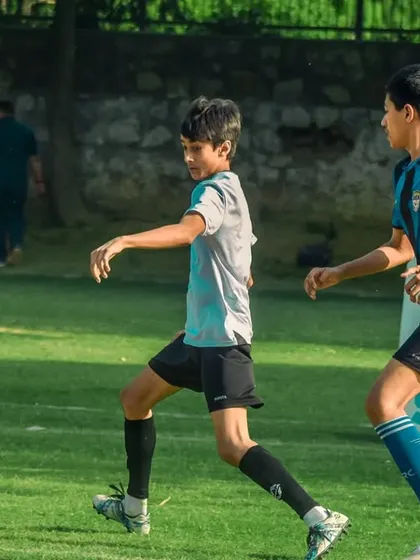 A player in a grey shirt leads the attack.