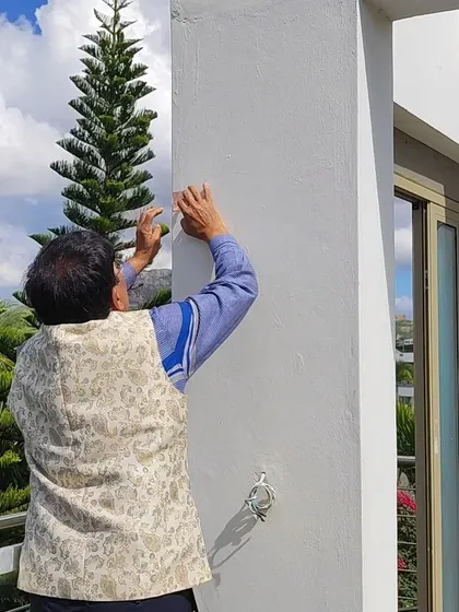 Carefully placing a Vedic Yantra on a pillar at a client's home in Mauritius. Each placement is precise, designed to channel positive energy and correct specific Vaastu defects without any structural changes.