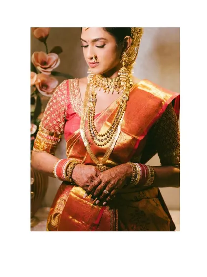 An elegant portrait of a South Indian bride. The rich colors of her saree and the intricate gold jewelry are beautifully captured in this timeless shot.