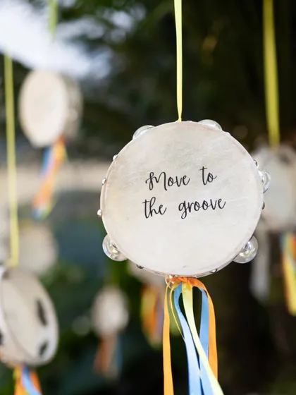 A close-up of a hanging tambourine with the hand-lettered message "Move to the groove," perfectly capturing the interactive and joyful spirit of the event.