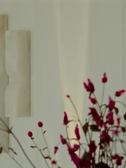 A detail of the sculptural wall sconces, which cast a soft, warm glow. These elements are like jewelry for the home, adding a final touch of elegance.