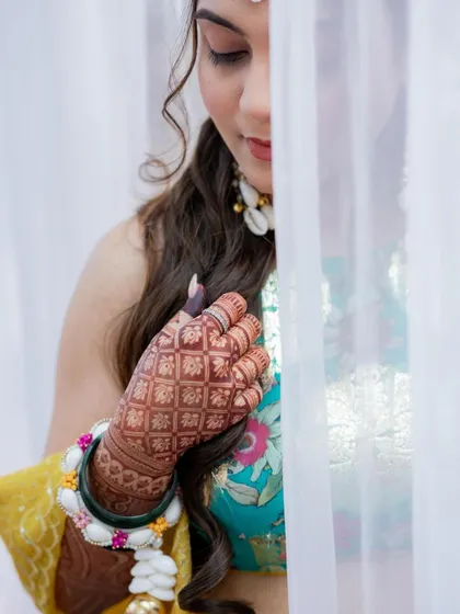 An artistic shot of the bride and her deep henna stain, partially hidden by a veil.