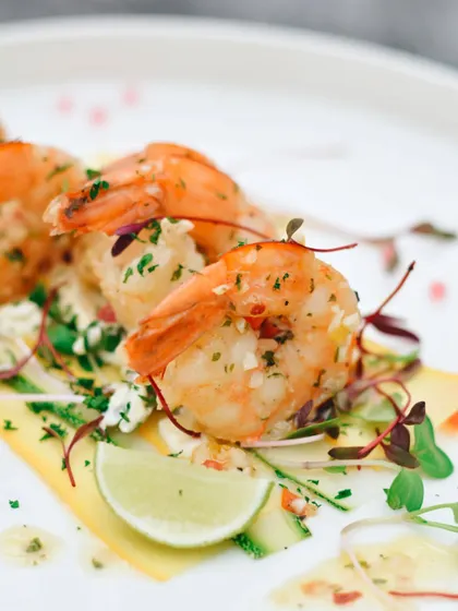 A close-up on these perfectly cooked garlic butter prawns. The focus is on the juicy texture and fresh garnish, making the dish look incredibly fresh and appetizing.
