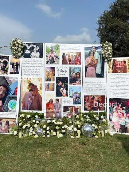 The central memory wall, a collage of the couple's favorite photos and meaningful text, surrounded by white flowers and disco balls.