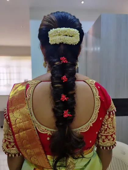 A simple yet beautiful bridal braid. This style uses a mix of jasmine and small red flowers for a touch of colour, paired with a neat bun.