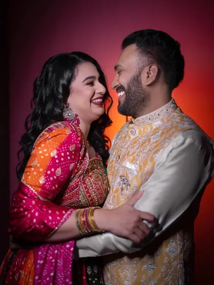 Vibrant colors and even more vibrant smiles. This studio-style portrait captures the fun and festive energy of a pre-wedding event like the Sangeet.
